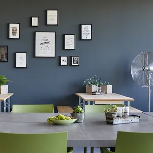 Blick in den Pausenbereich mit Tischen und Bildern an der Wand.