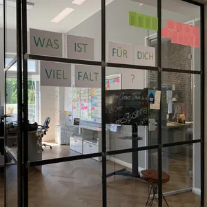 Blick auf die Diversity-Wand im Office in Essen mit der Aufschrift „Was ist für dich Vielfalt?“ und mehreren handschriftlichen Kommentaren.