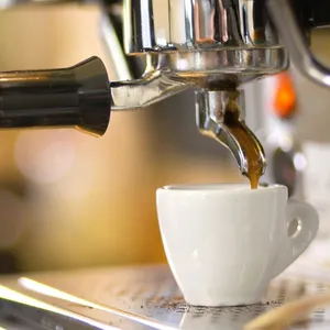 Eine Tasse wird an der Kaffeemaschine gefüllt.