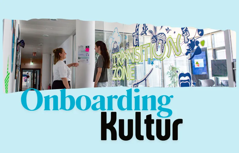 Zwei Mitarbeiterinnen unterhalten sich vor einer einer Glaswand mit der Aufschrift „Transition Zone“. Unter dem Bild steht in großen Buchstaben „Onboarding Kultur“.
