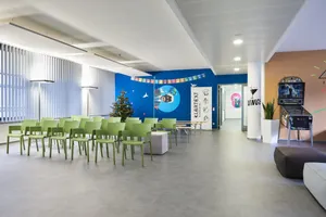 Blick in den Lounge- bzw. Veranstaltungsbereich des Büros mit aufgereihten Stühlen und bunt gestalteten Wänden.