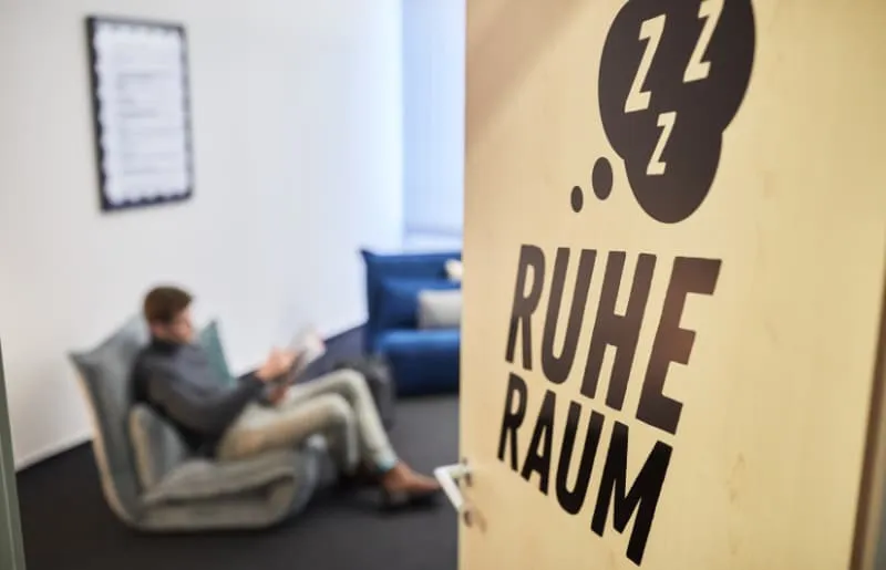 Ein Mitarbeiter entspannt auf einem Sofa im Ruhe-Raum des Büros.