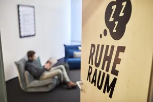 Ein Mitarbeiter entspannt auf einem Sofa im Ruhe-Raum des Büros.